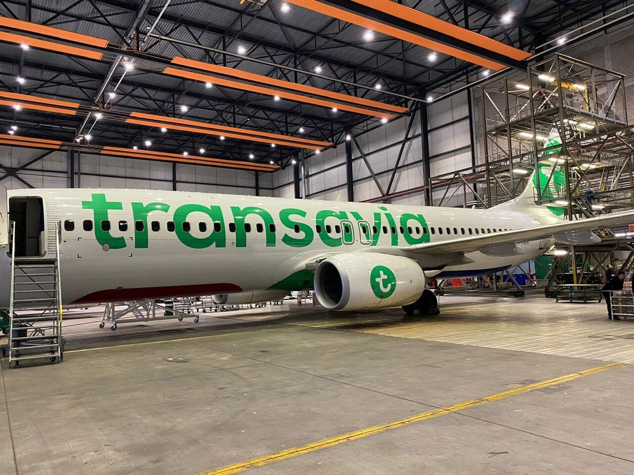 Een Transavia-vliegtuig staat in een hangar voor onderhoud.