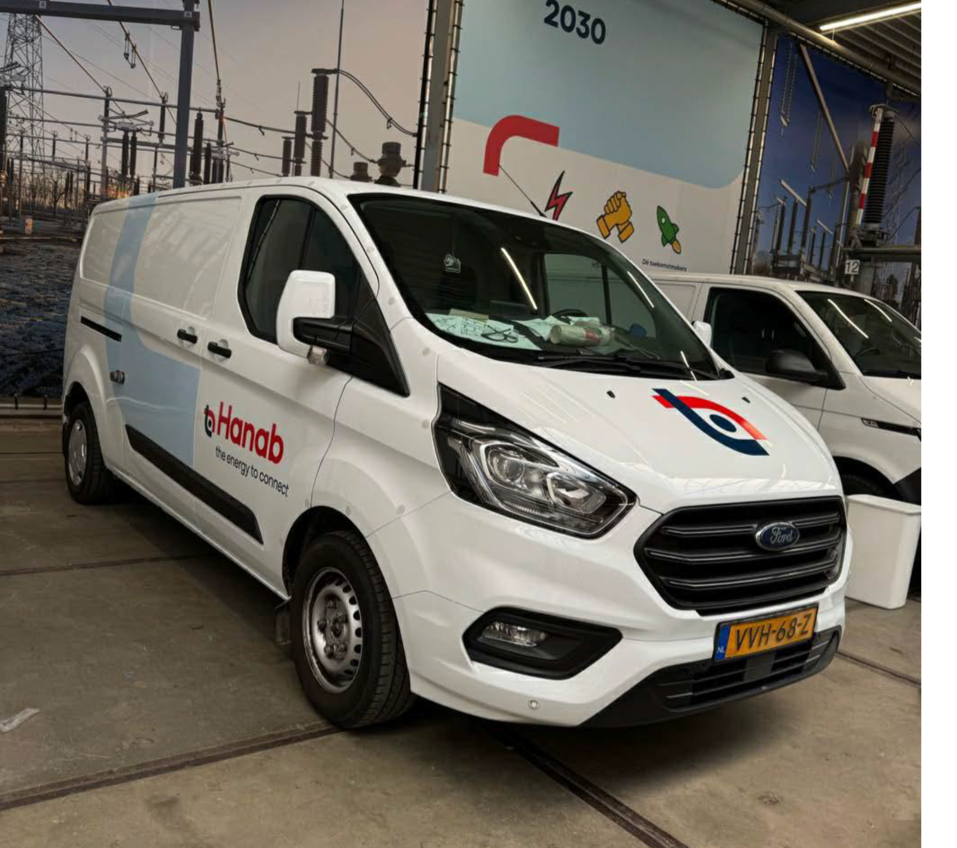 Witte bestelwagen van Hanab met bedrijfslogo, in een industriële omgeving.