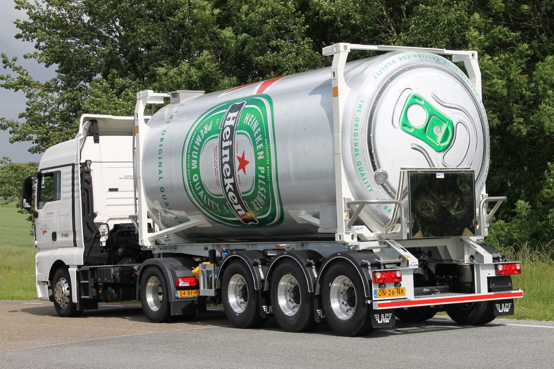 Een vrachtwagen met een grote Heineken tankcontainer op de weg.
