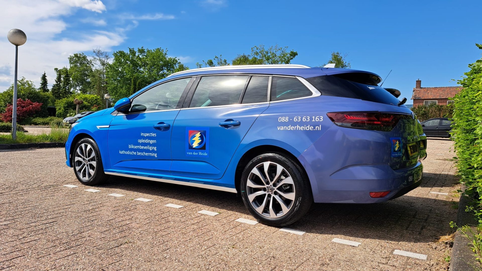 Blauwe auto met bedrijfslogo van 