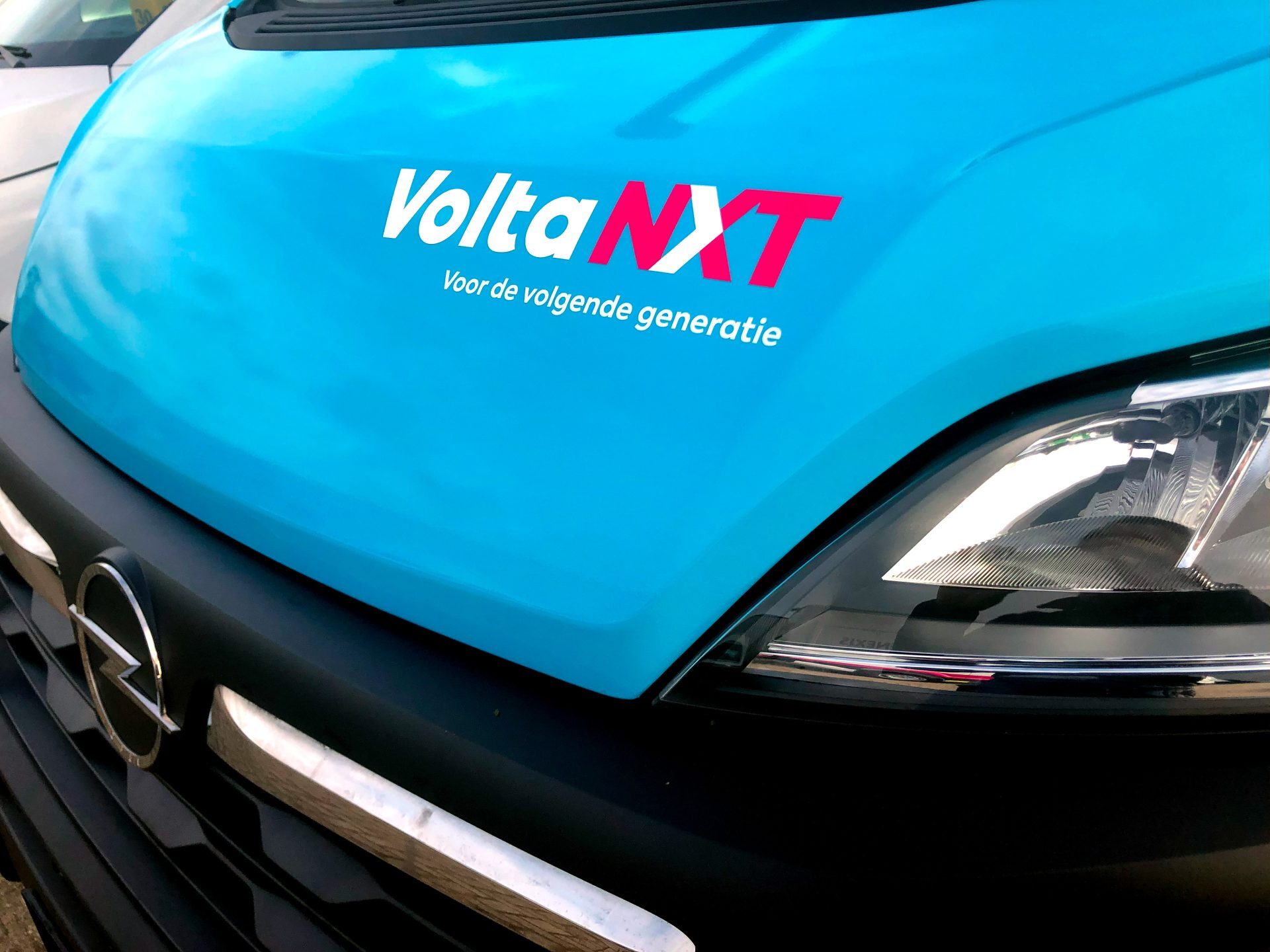 Close-up van de voorkant van een blauwe Opel bestelwagen met het logo 
