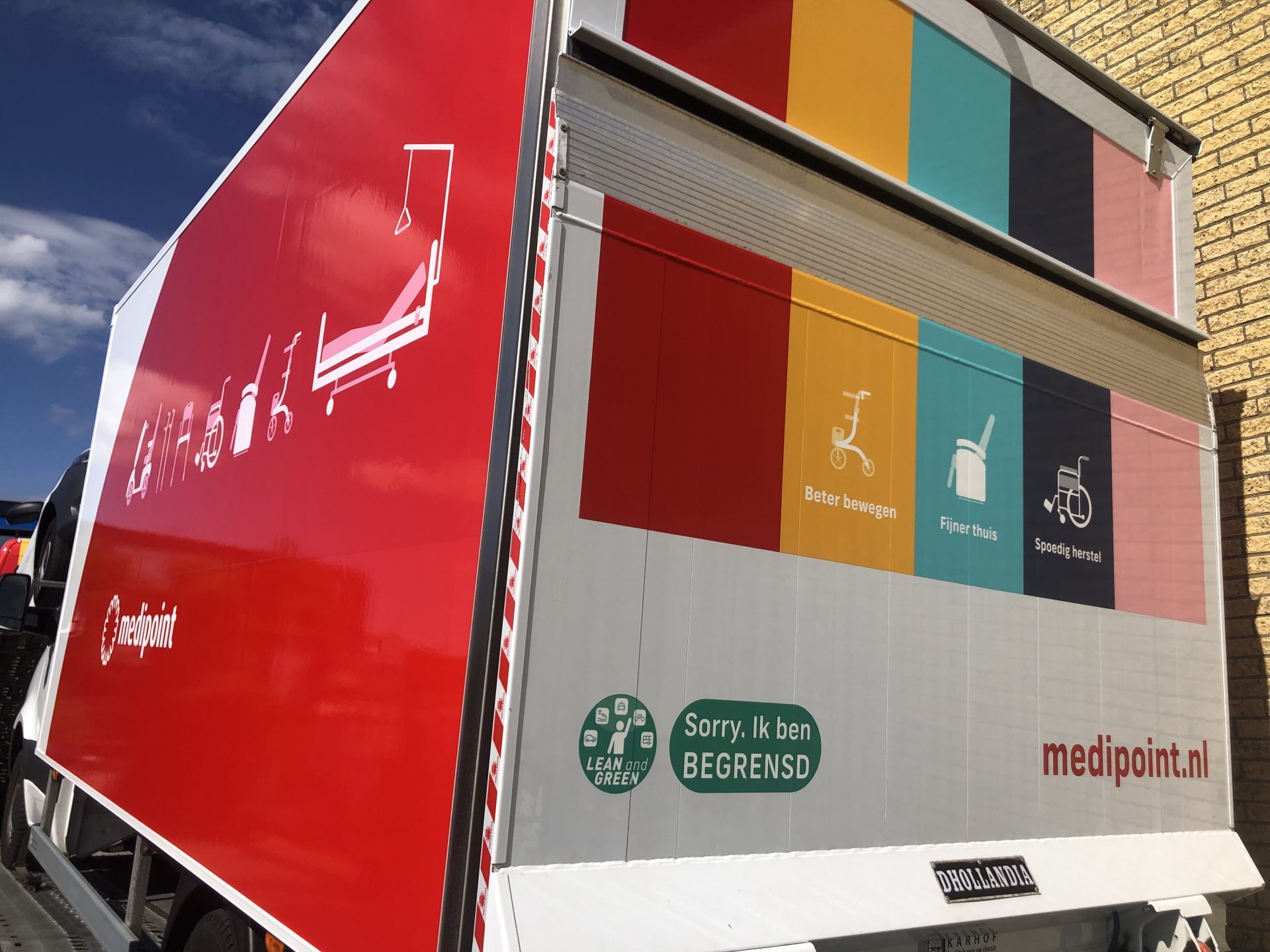 Vrachtwagen met kleuren en iconen van Medipoint en slogans over beweging, thuiscomfort en herstel.