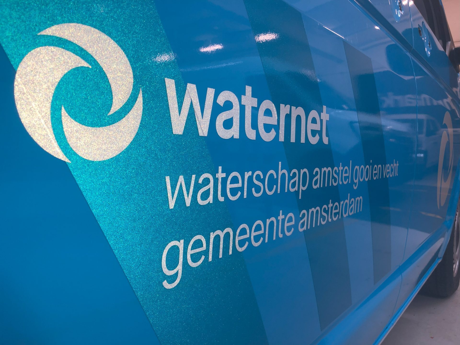 Blauw voertuig met het logo en de tekst van Waternet, waterschap Amstel, Gooi en Vecht, gemeente Amsterdam.