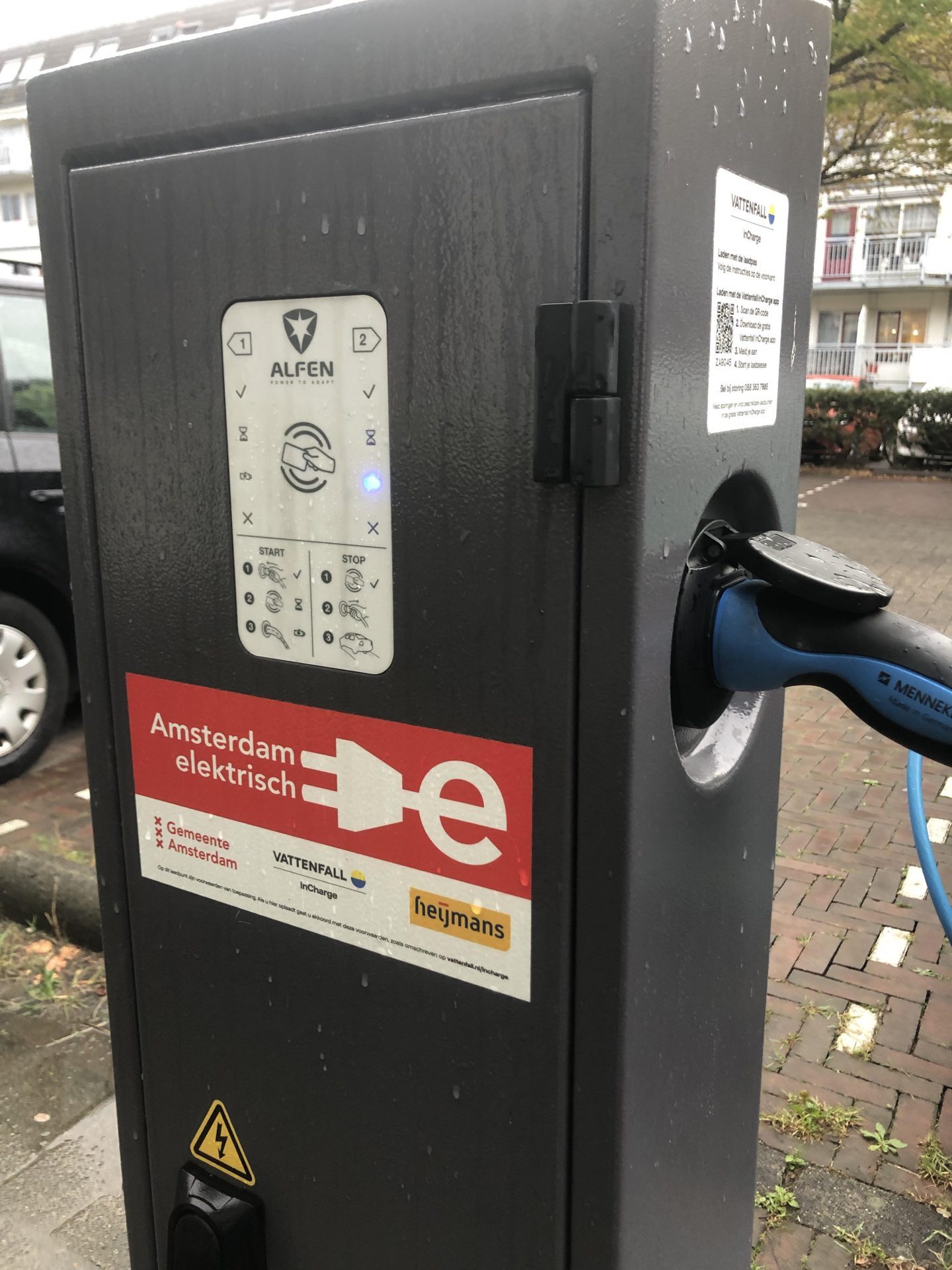 Laadpaal met logo's van Amsterdam Elektrisch, Vattenfall en Heijmans.