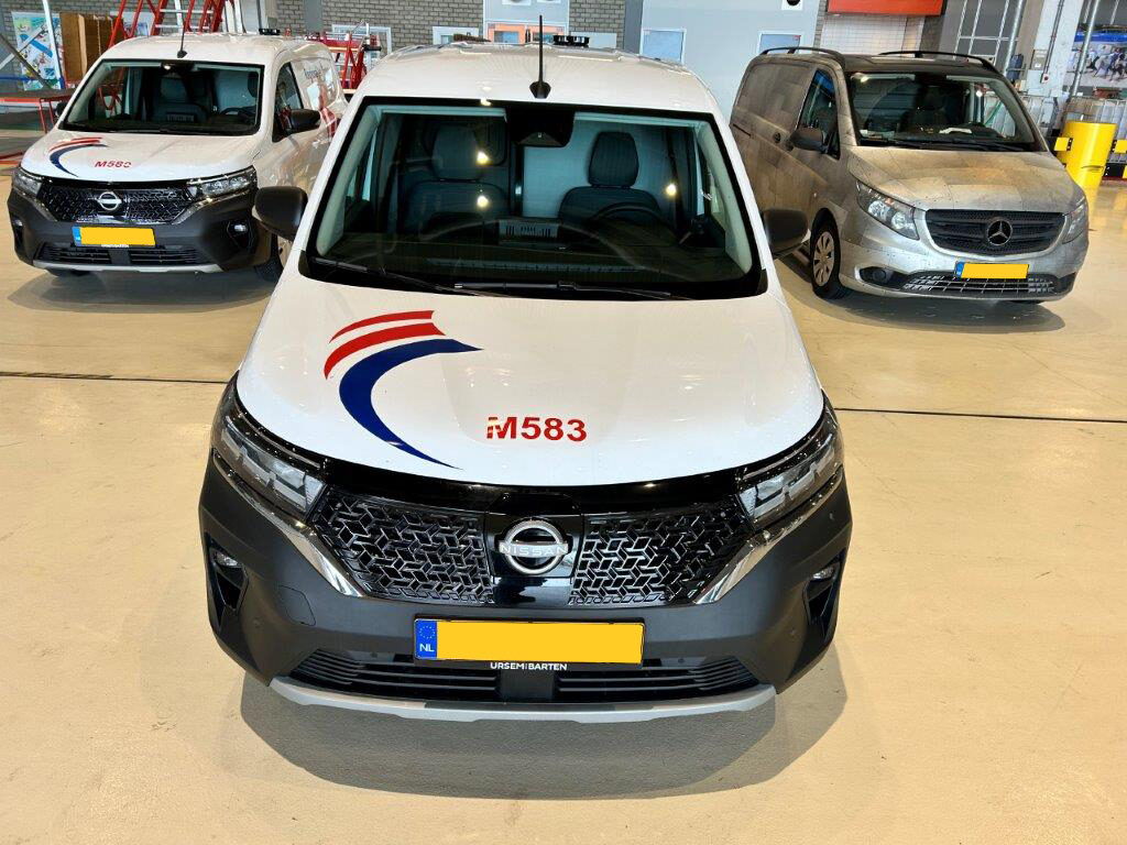 Drie bedrijfsauto's, waarvan twee met het logo en opschrift 