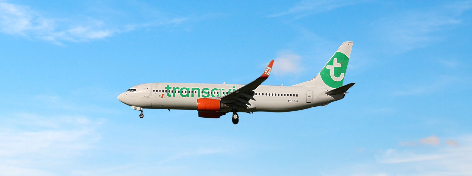 Transavia-vliegtuig in de lucht tegen een blauwe hemel.