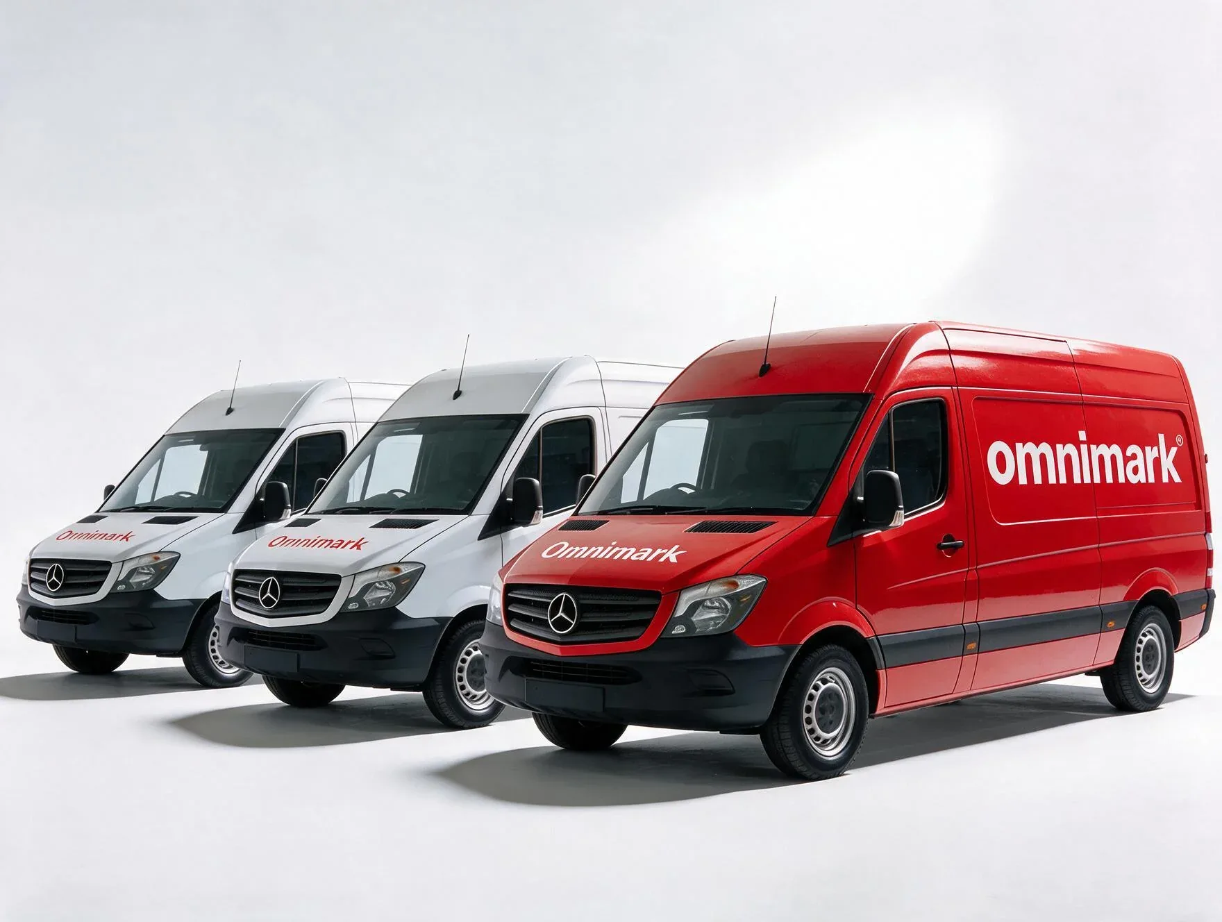 Drie Mercedes bestelwagens, waarvan één rood en twee wit, met de tekst 