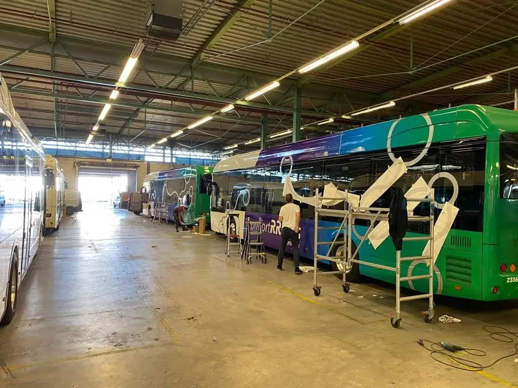 Bussen worden gerepareerd in een grote werkplaats.