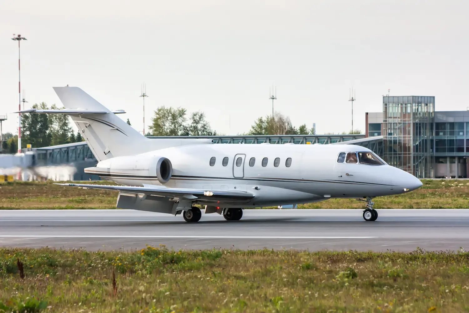 Een zakenjet op de landingsbaan voor de terminal van een luchthaven.