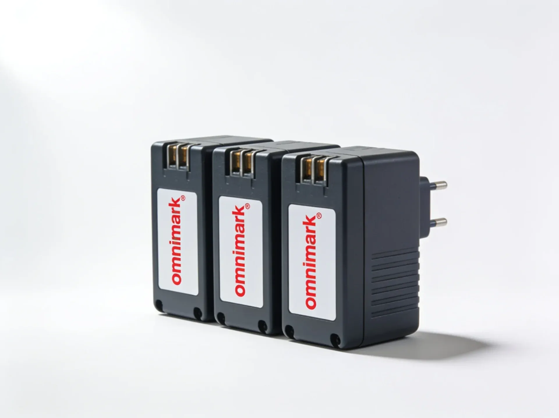 Drie zwarte elektronische adapters met de merknaam 