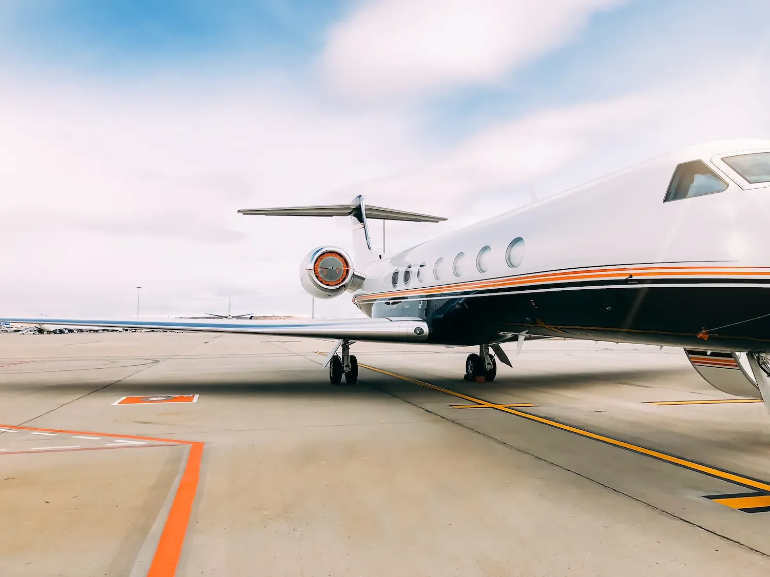 Een luxe privéjet geparkeerd op een vliegveldterrein.