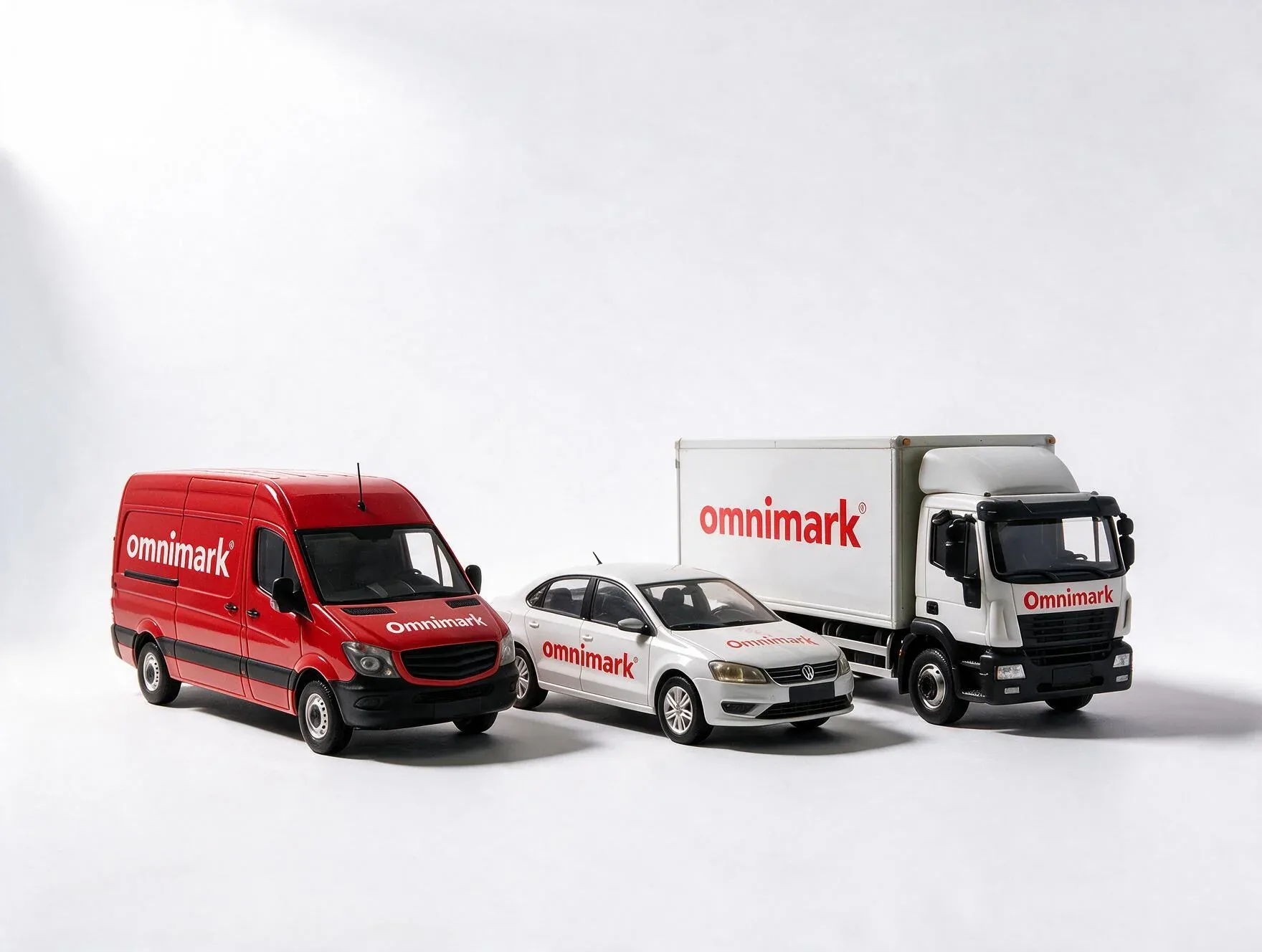 Een rood busje, een witte auto en een witte vrachtwagen met het logo 